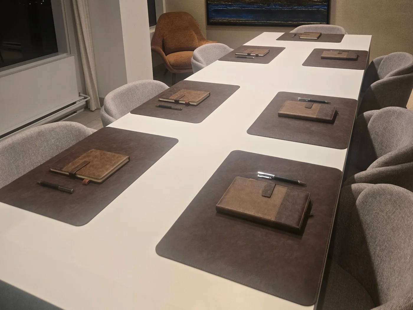 Brown VIP Setup on a boardroom table: desk pads, notebooks and pens at every seat